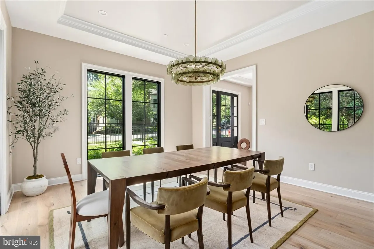 Dining room with dark wood table, brass pendant light, and glass doors