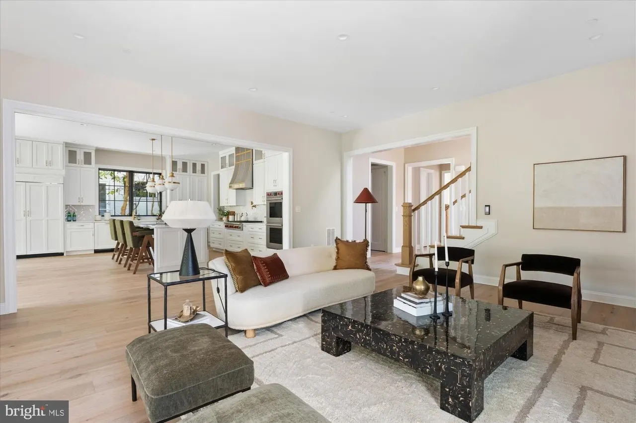 Open concept living room with kitchen, sofa, and stairs visible