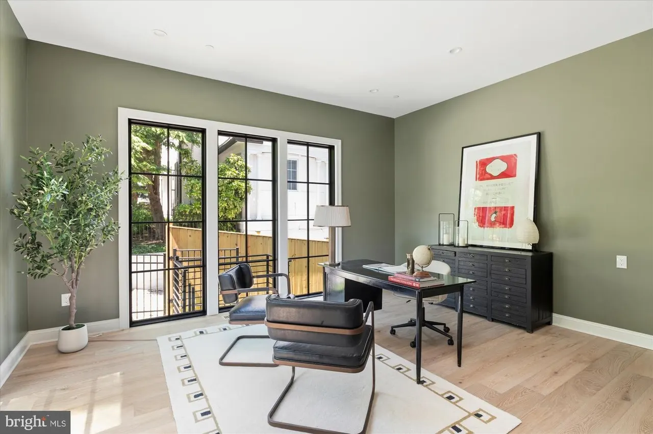 Home office with desk, glass doors to deck, and green walls