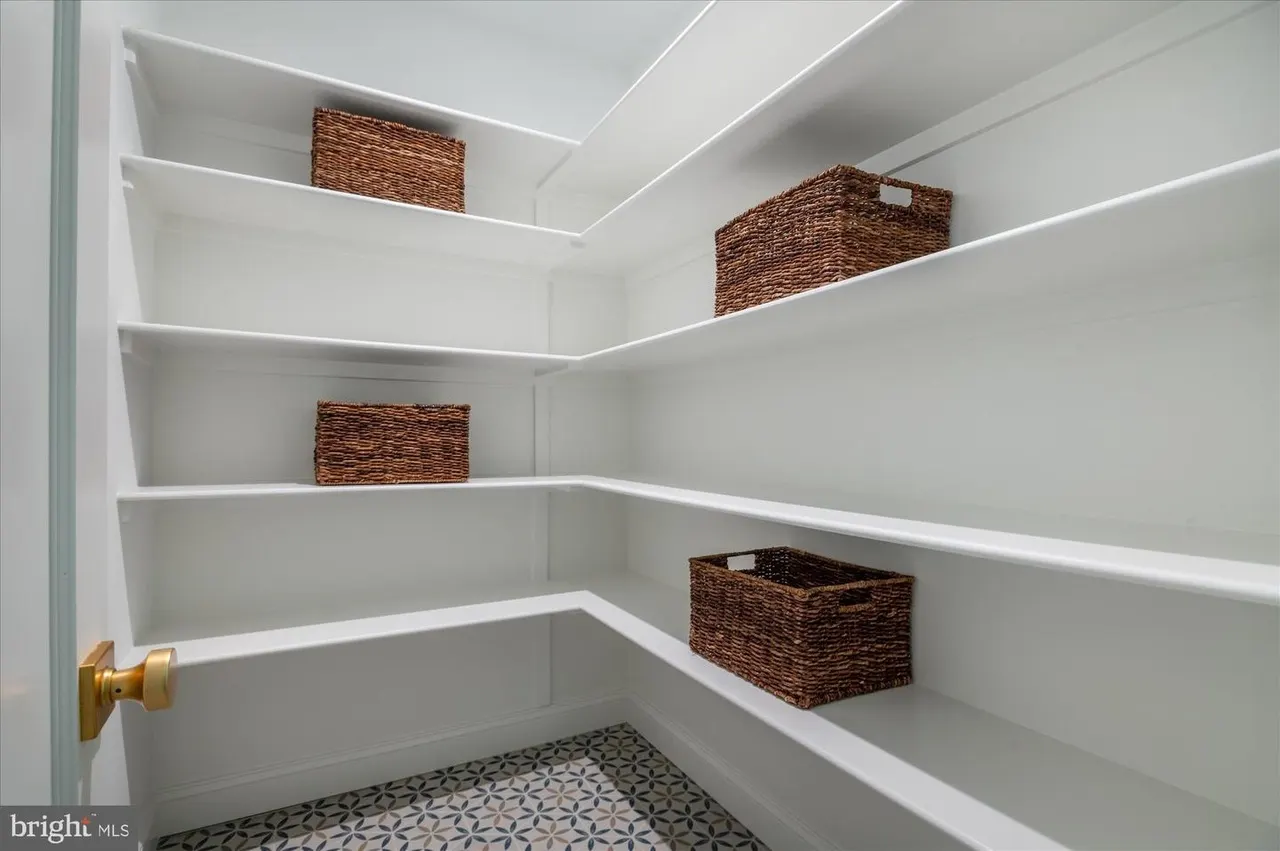 Walk-in closet with white shelving and woven storage baskets
