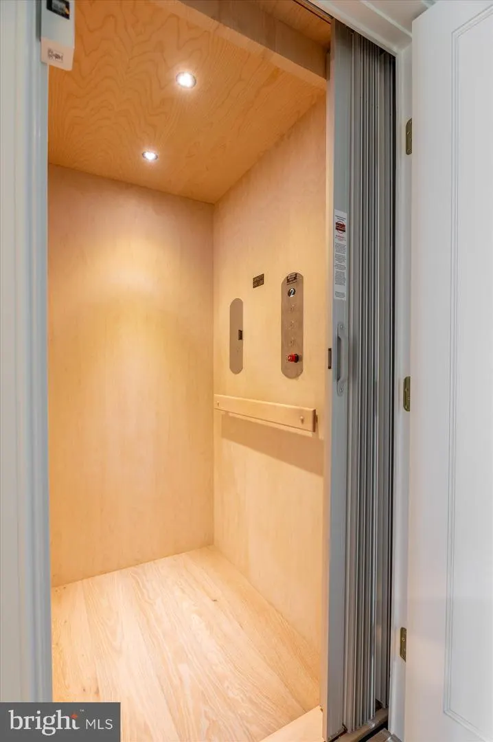 Wooden elevator interior with light wood paneling