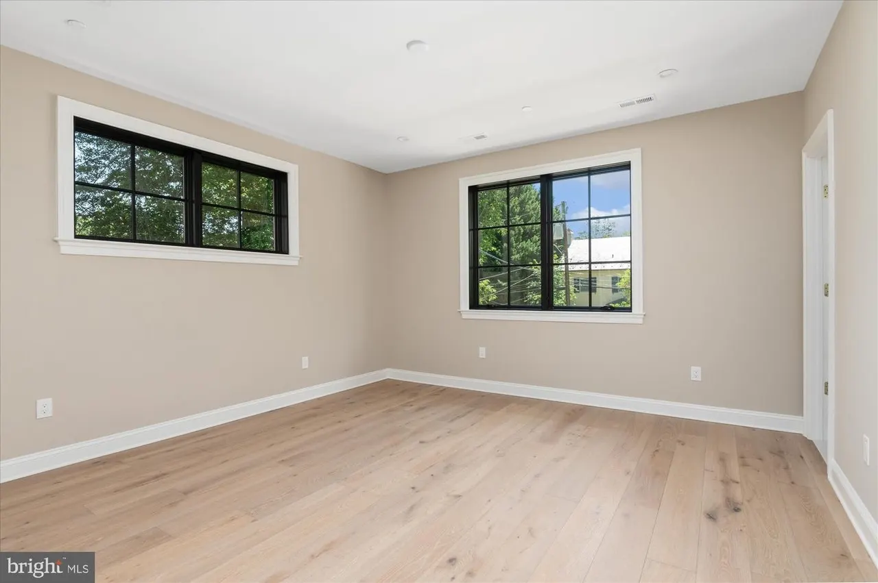 Bedroom with hardwood floors and black-framed windows