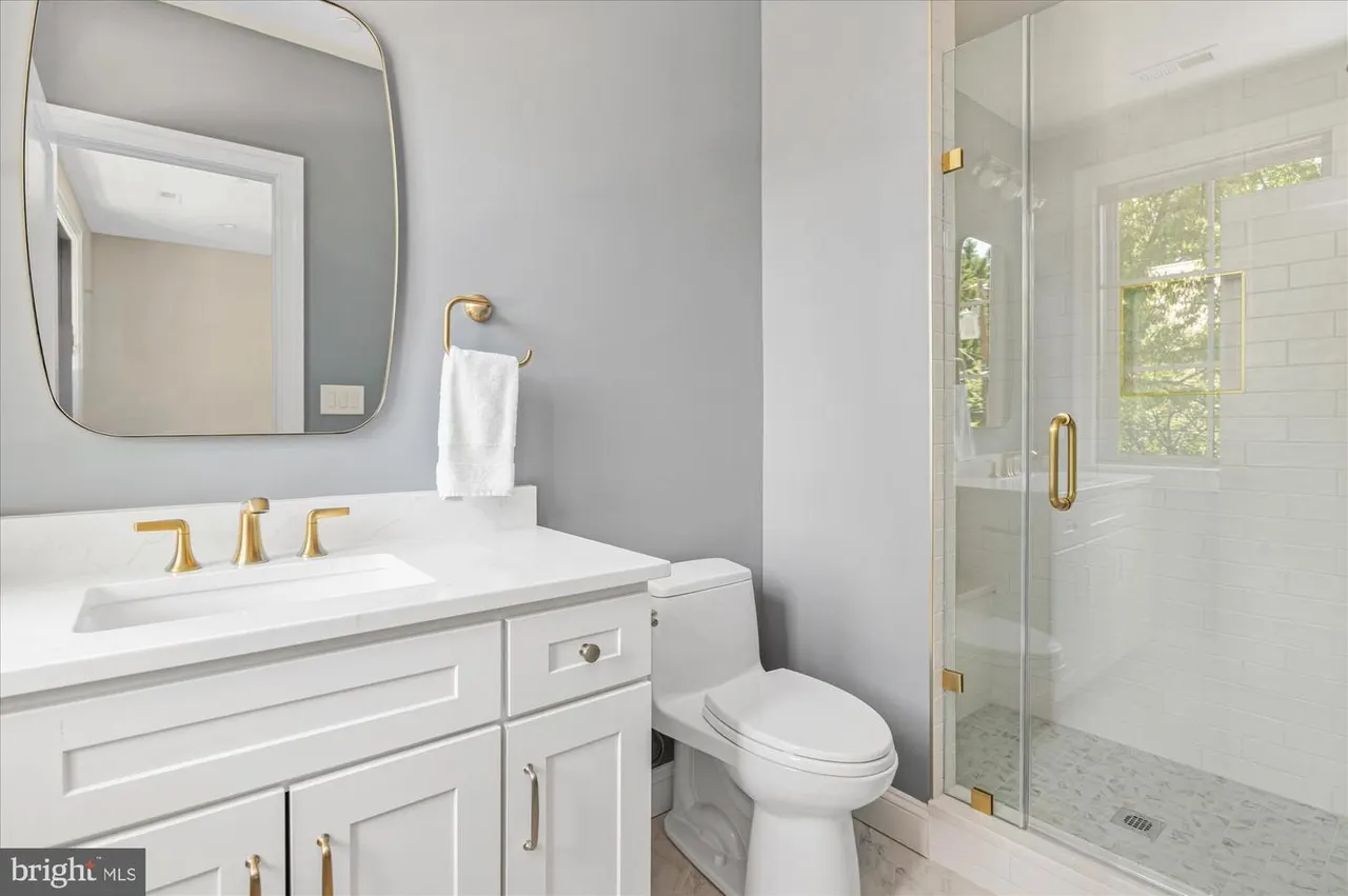Bathroom with white vanity, gray walls, and walk-in shower