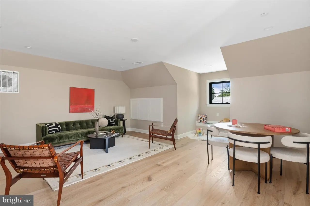 Open living and dining area with green sofa and vaulted ceilings