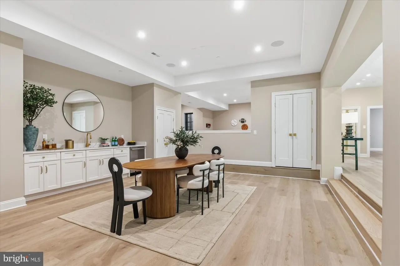 Dining room with wood table, black chairs, and white cabinetry