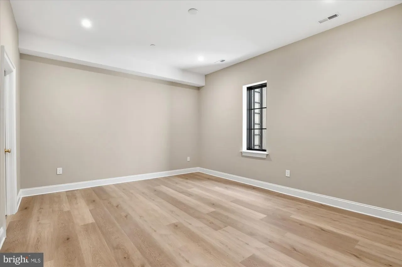 Empty bedroom with wood flooring and white trim