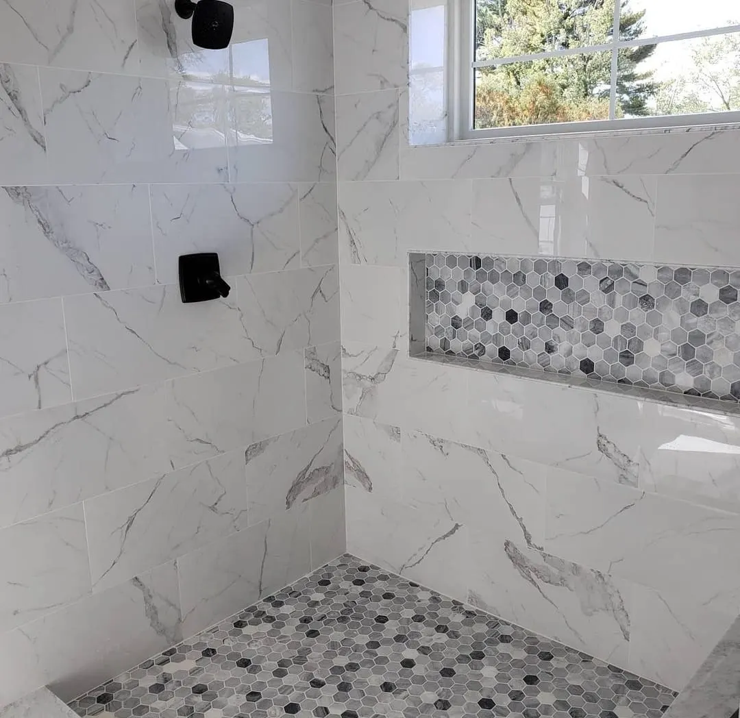 Walk-in shower with marble-look tile and hexagon mosaic accents