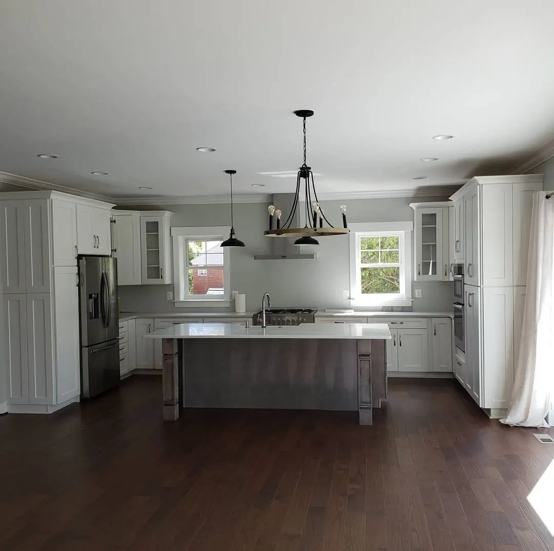White kitchen with wood-toned island and dark hardwood floors