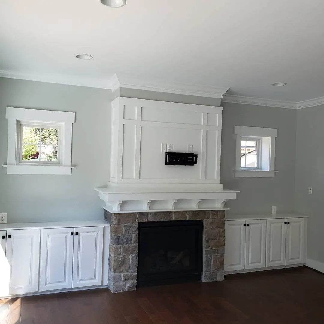 Family room fireplace with stone surround and white built-in cabinets