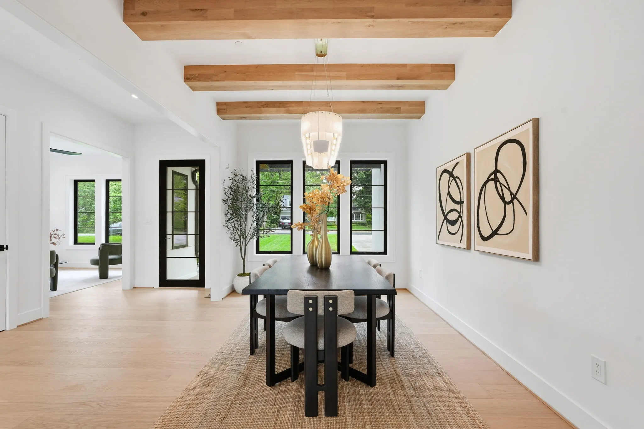 Dining room with exposed wood beams and black table with black chairs