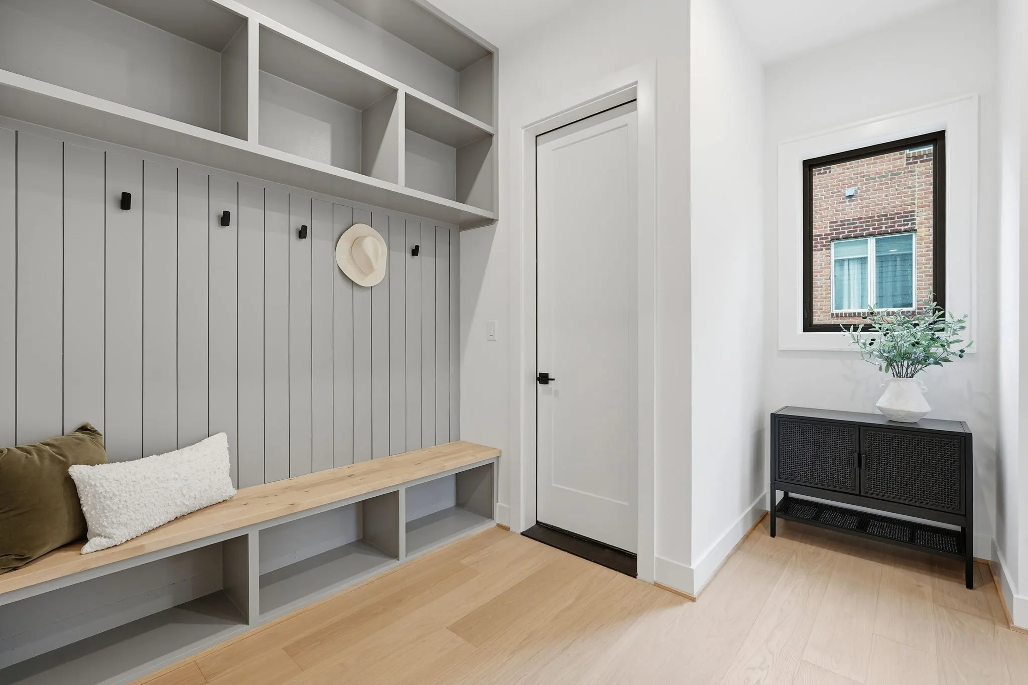 Mudroom with gray vertical shiplap, built-in bench, and upper shelving