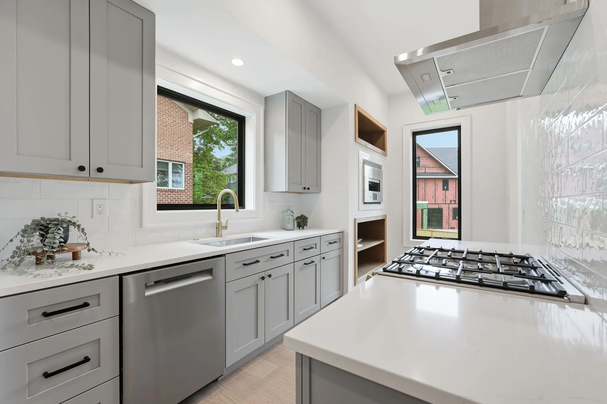 Kitchen with gray cabinets, gas cooktop, and multiple windows