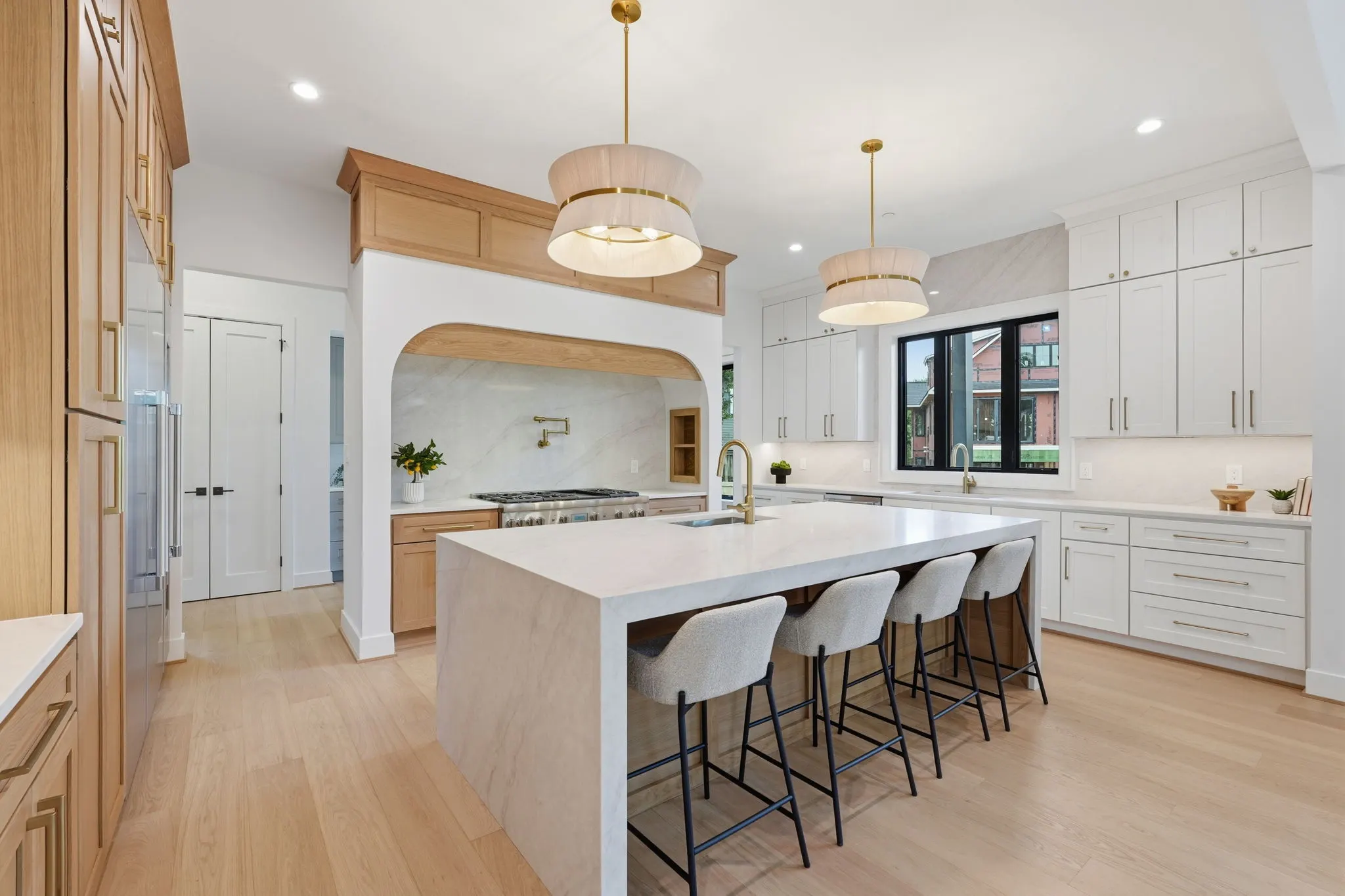 Kitchen with white island, mixed wood and white cabinetry, pendant lighting