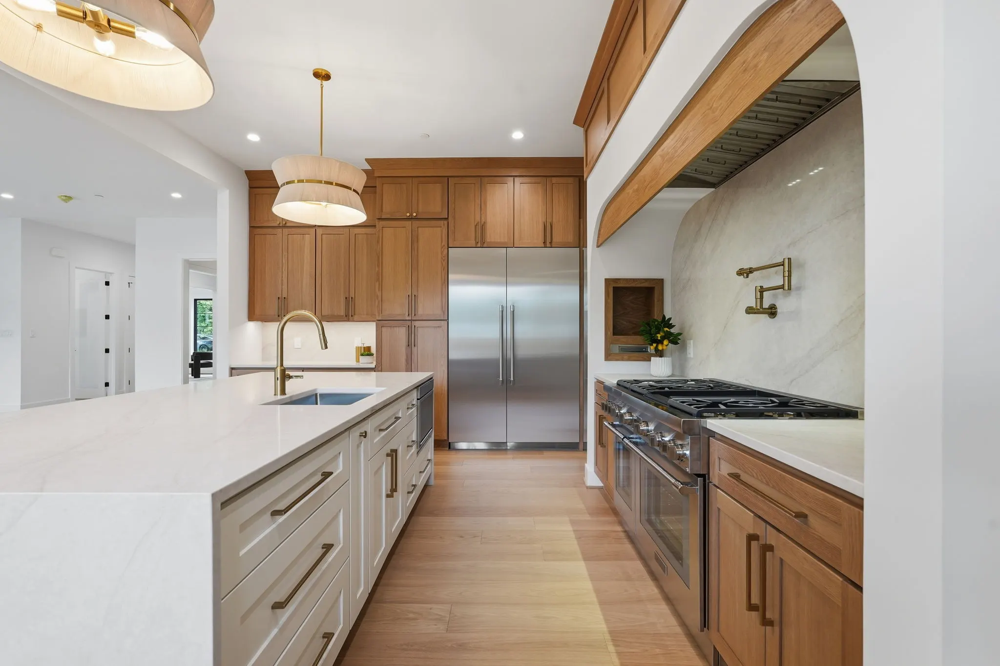 Kitchen with dual islands, wood cabinetry, stainless appliances, marble backsplash