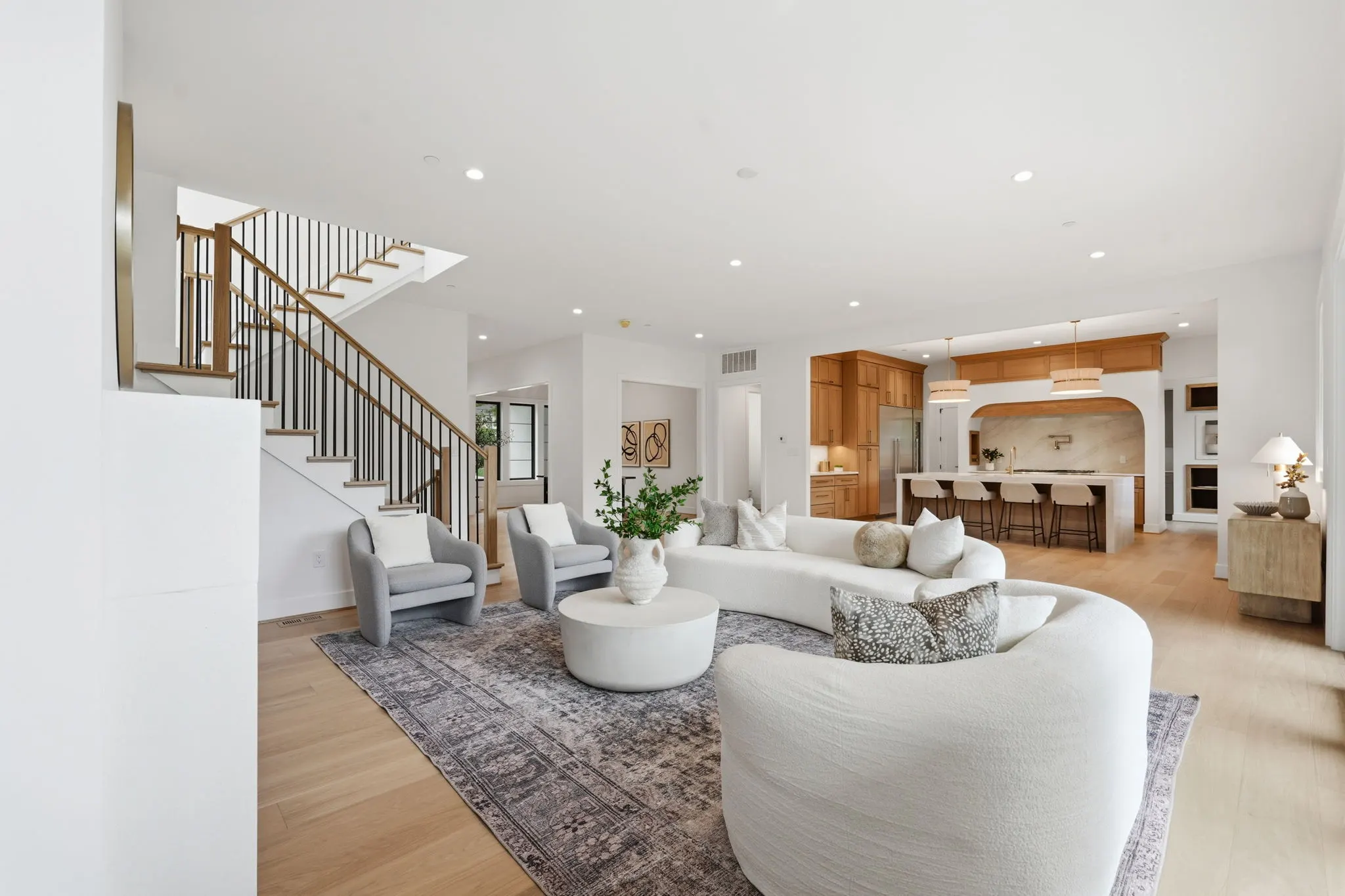 Open living space with kitchen, stairs, and modern seating