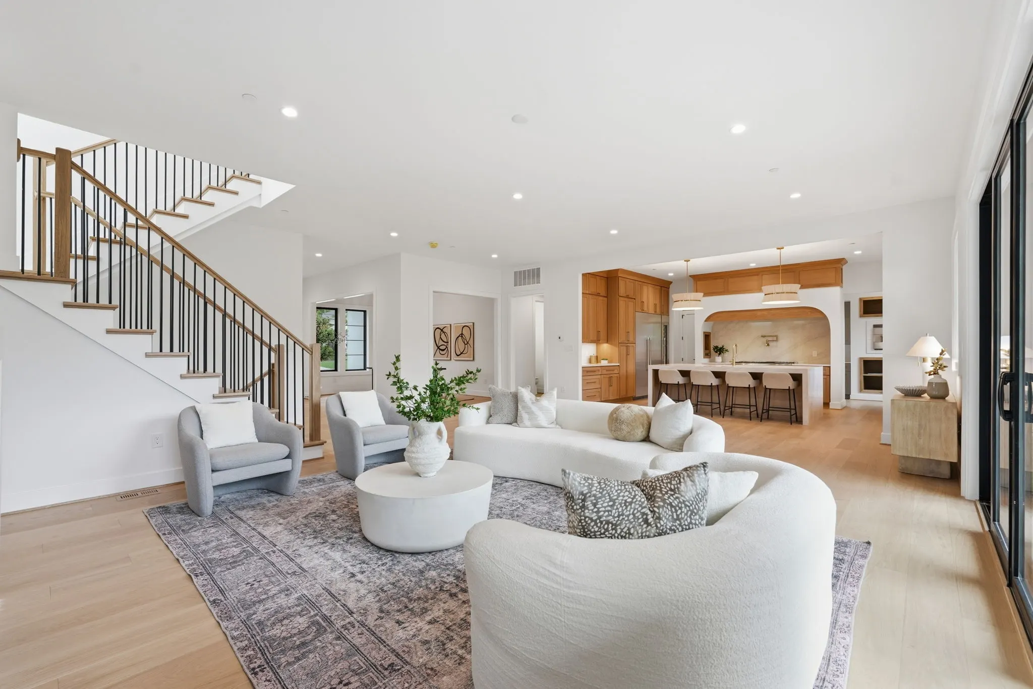 Living room with stairs, kitchen, and contemporary furnishings