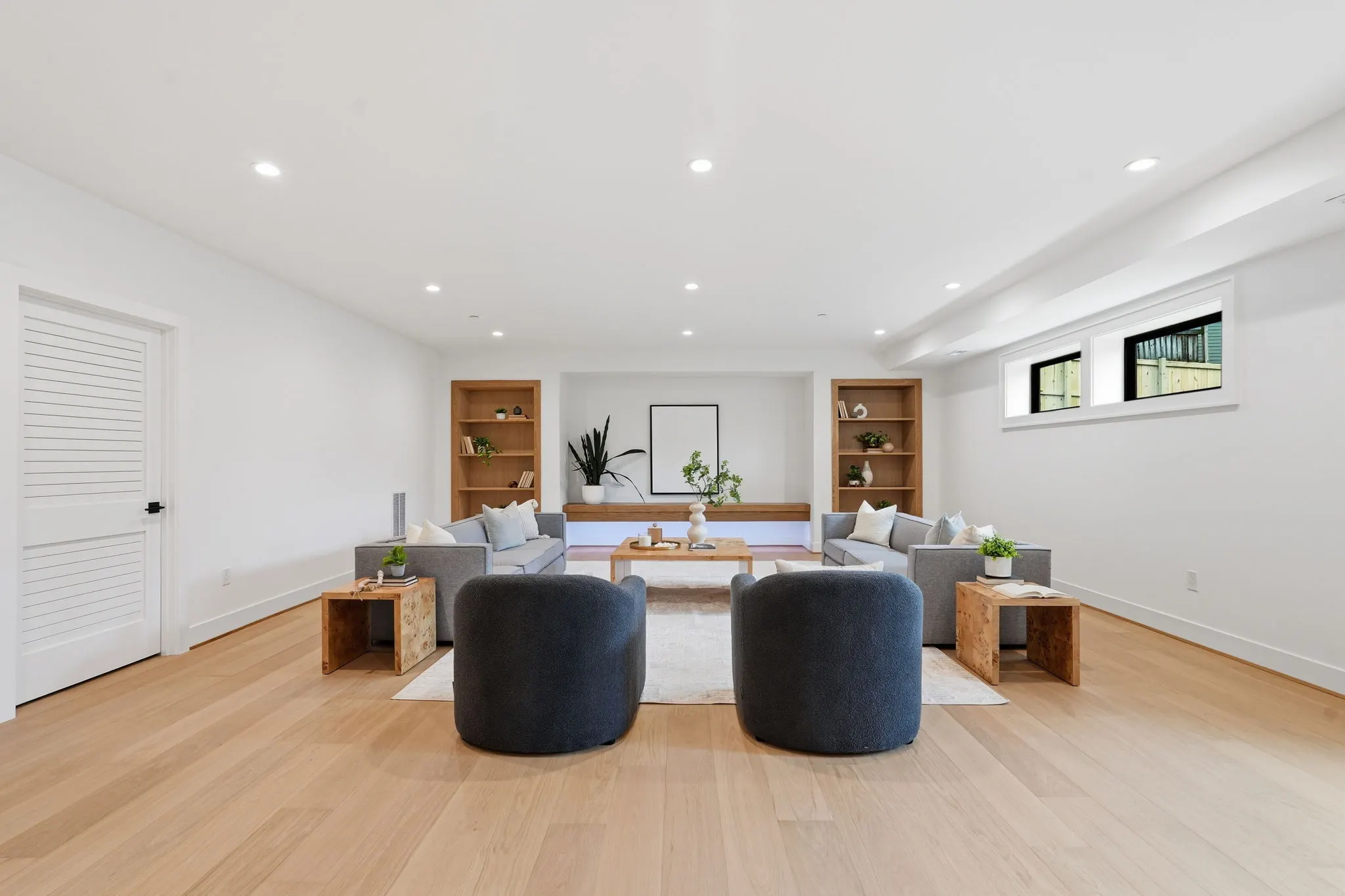 Recreation room with built-in shelving, seating areas, and natural light