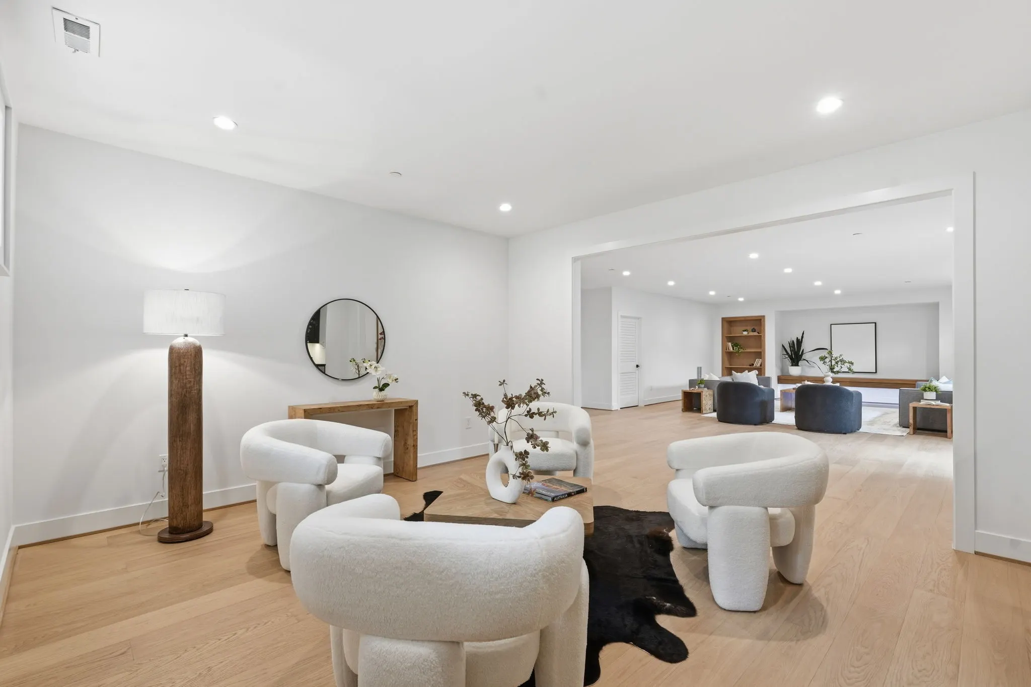 Open concept living and entertaining space with white sculptural chairs
