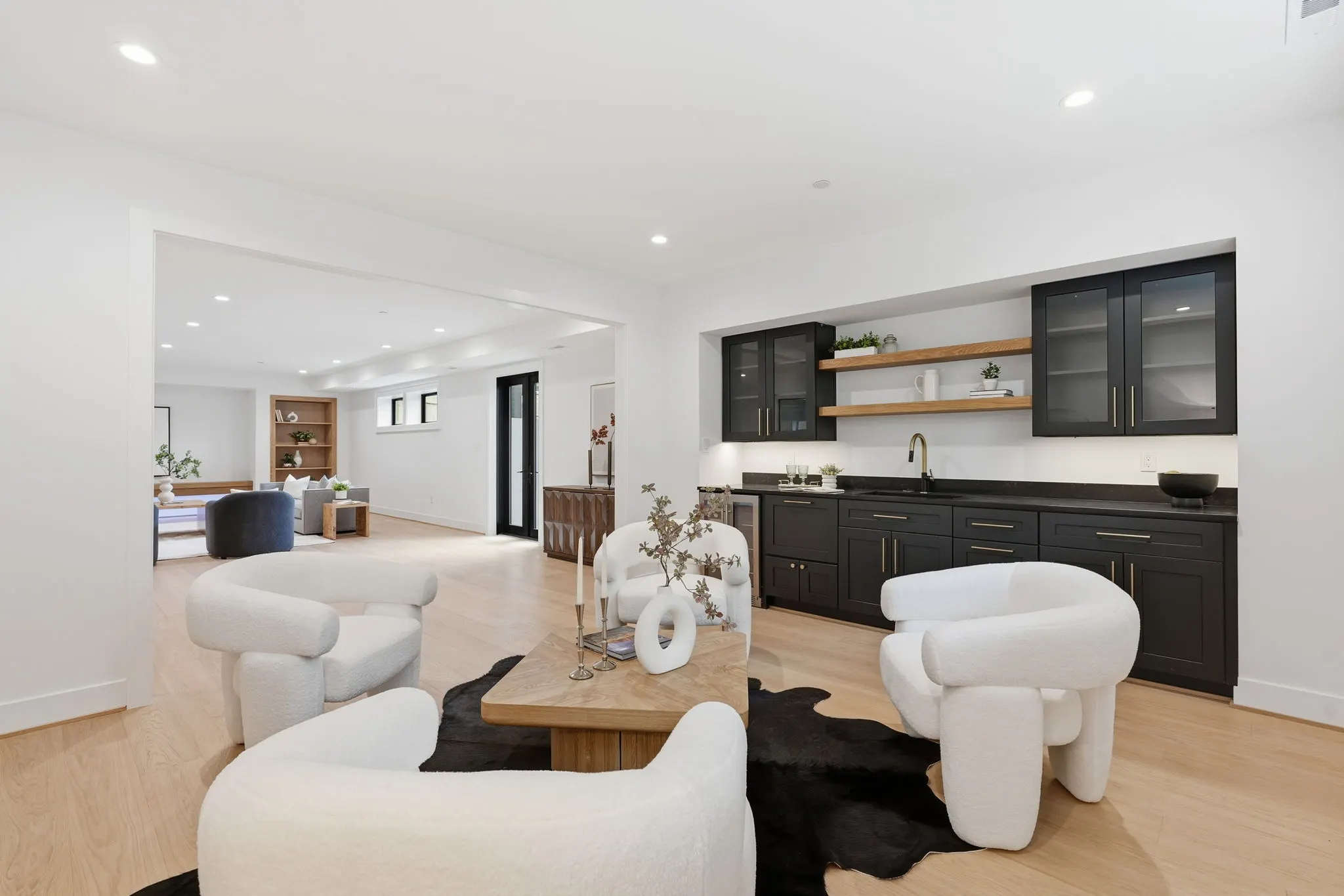 Living area with black kitchen cabinetry and white modern seating