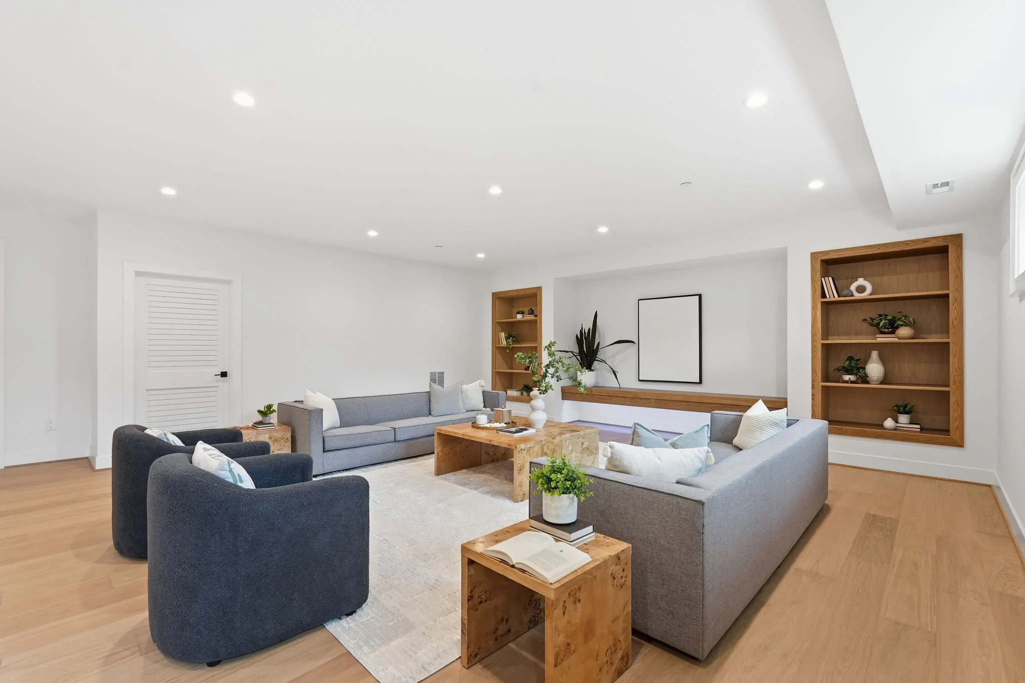Living room with curved gray seating and wooden display shelves