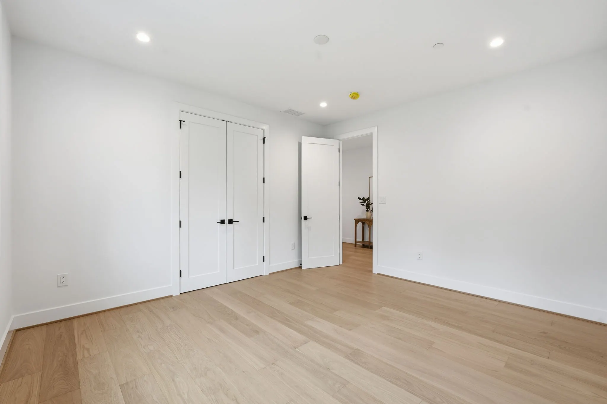 Bedroom with white closet doors and wood flooring