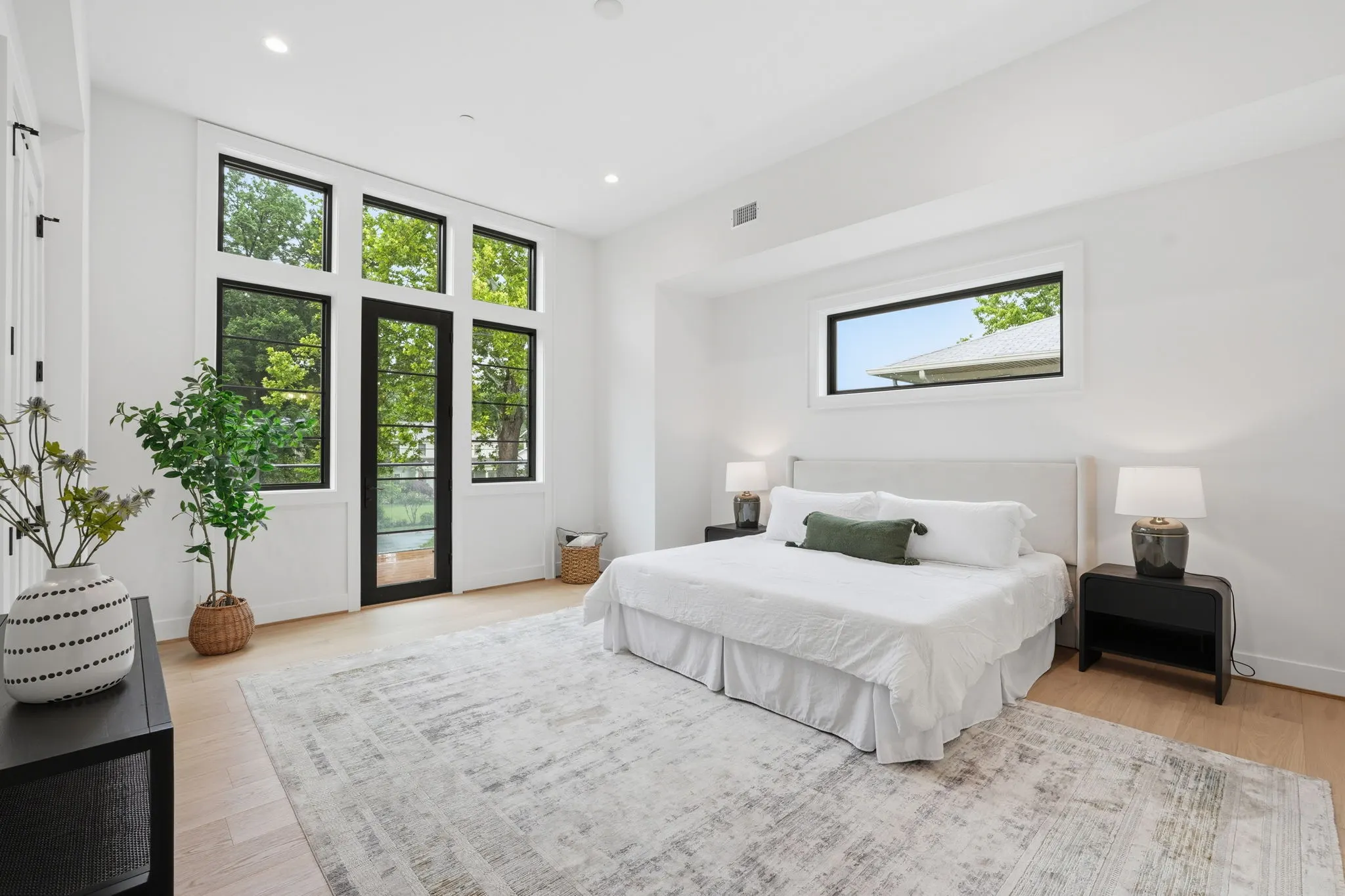 Primary bedroom with black-framed glass doors and windows