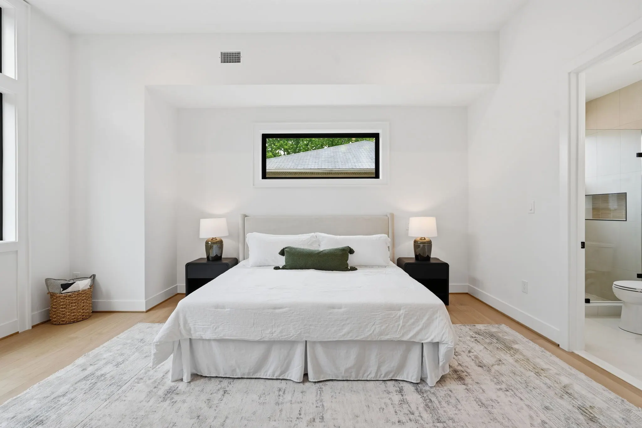 Primary bedroom with white bedding and black nightstands