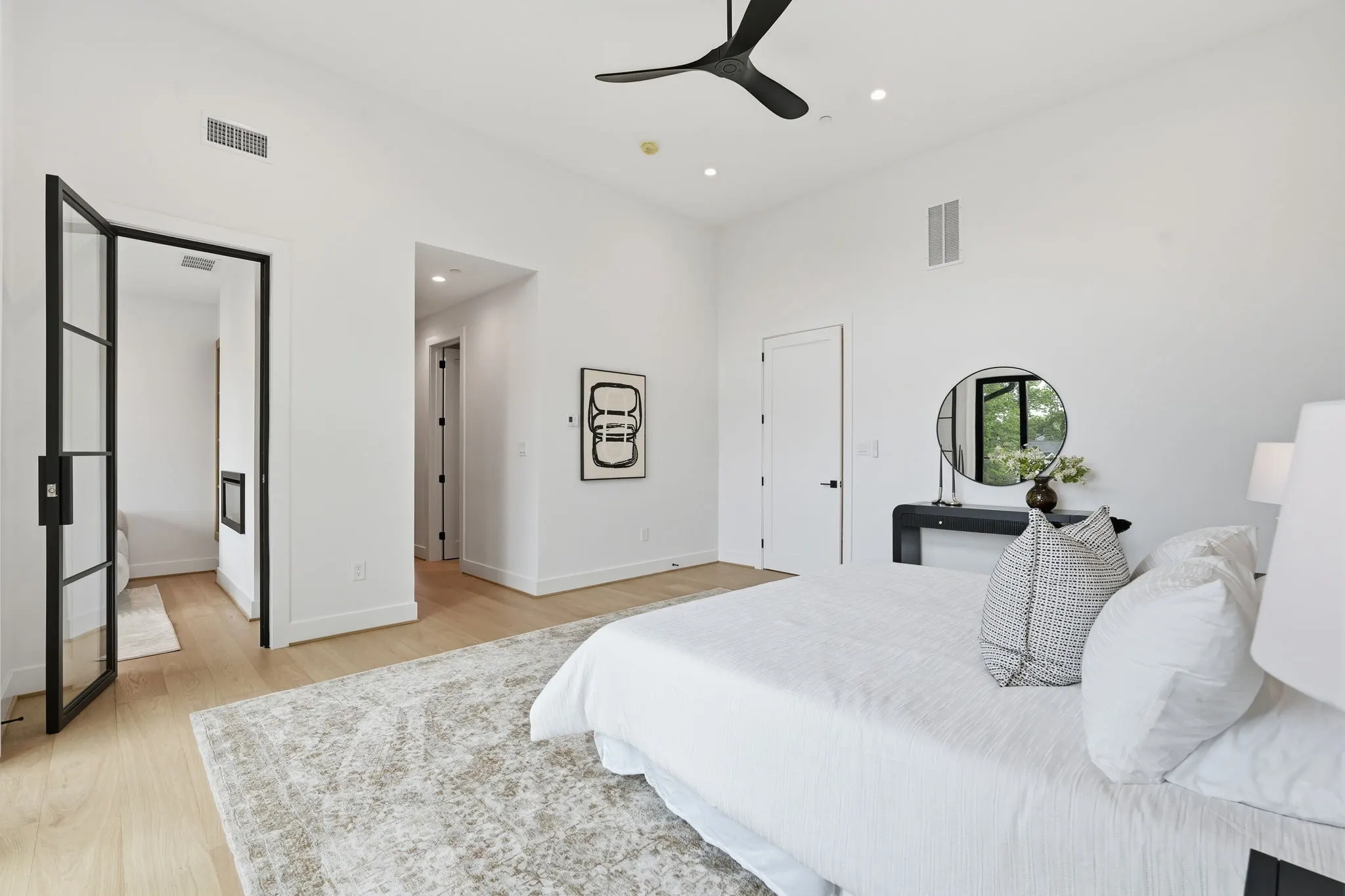 Bedroom with ensuite bathroom and black framed glass door entry