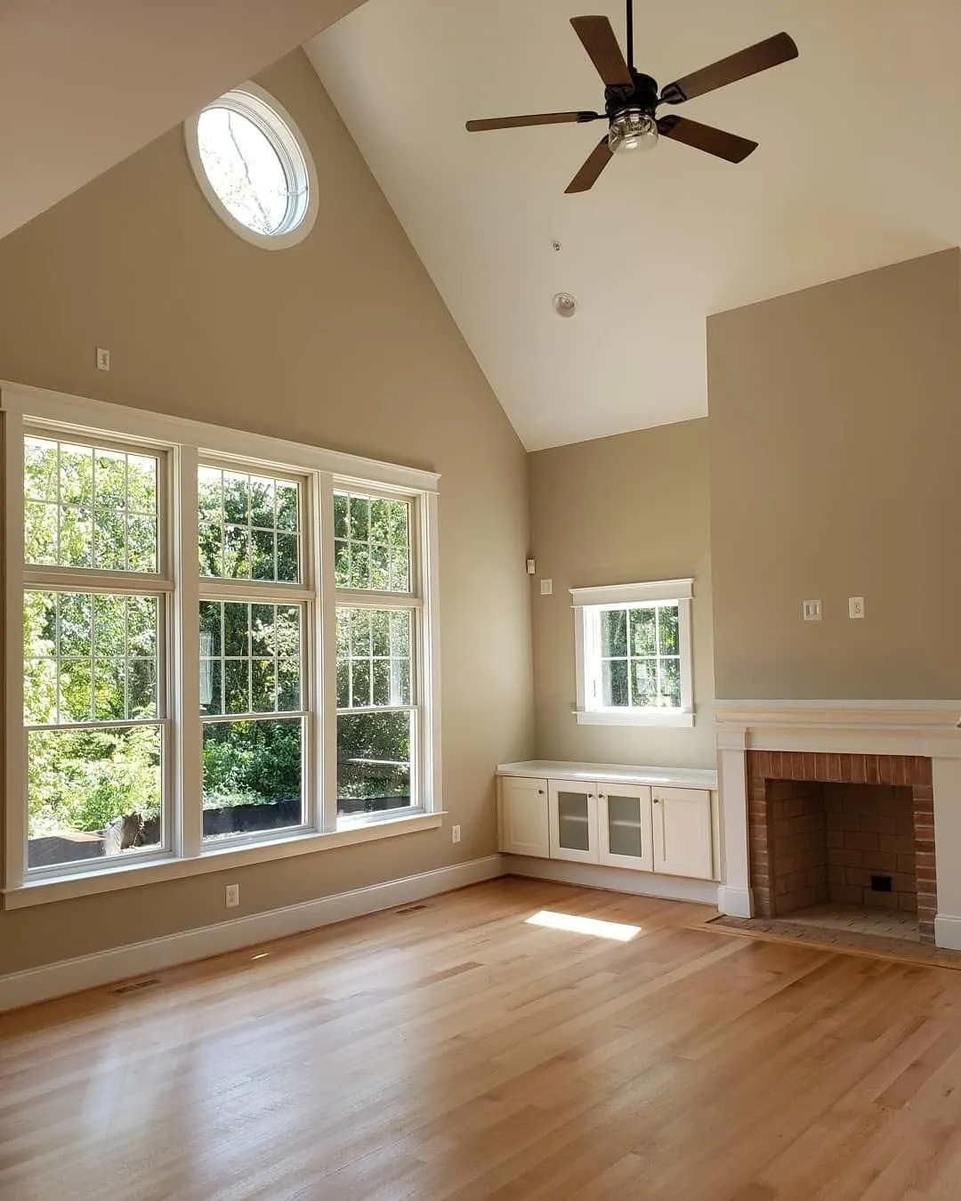 Living room with vaulted ceiling, fireplace, and large windows