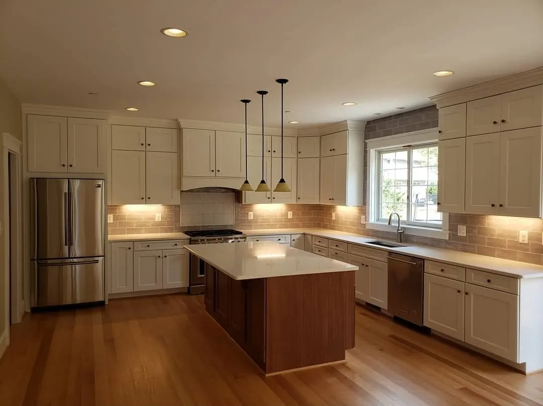 Kitchen with white cabinets, wood island, and pendant lighting