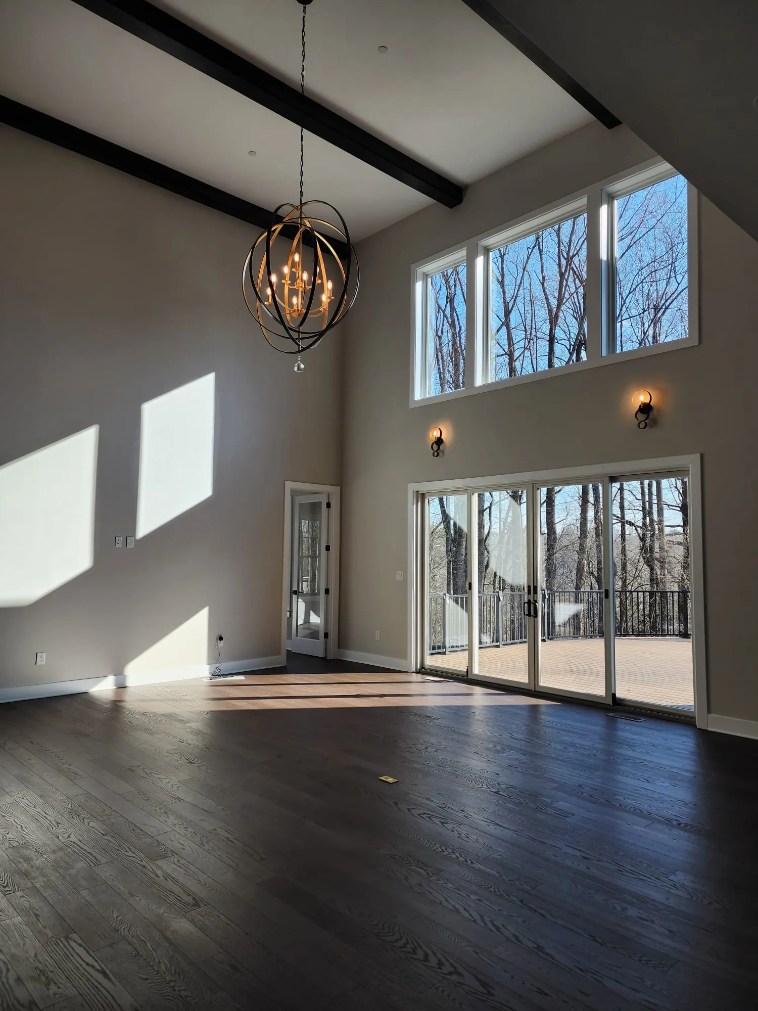 Great room with tall windows and sliding doors to deck