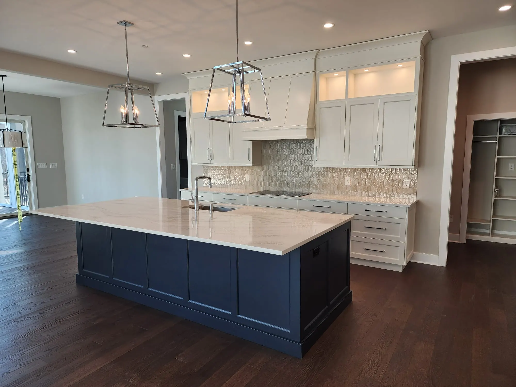 Kitchen island with quartzite counters and glass tile backsplash