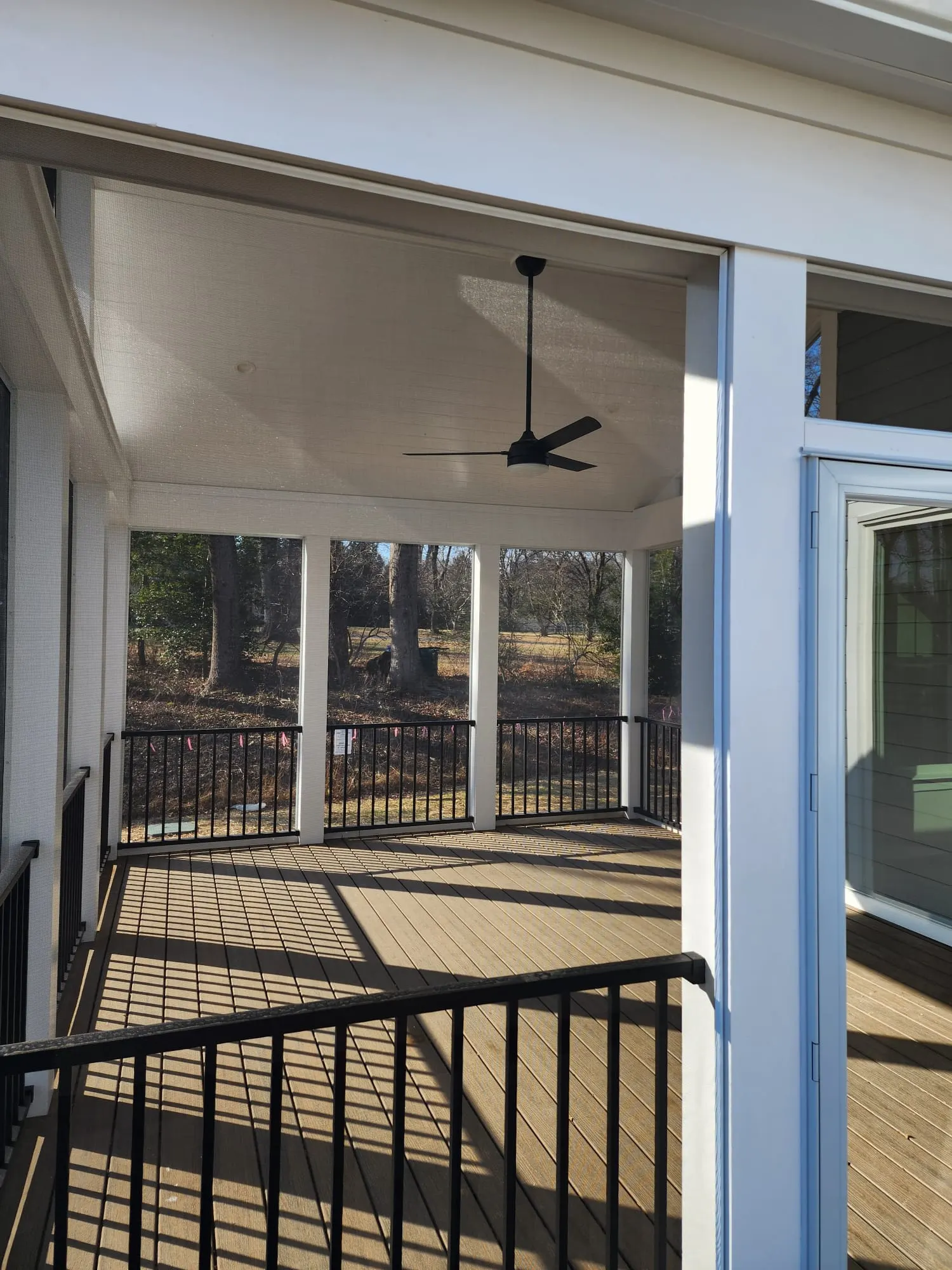 Screened porch with ceiling fan overlooking trees