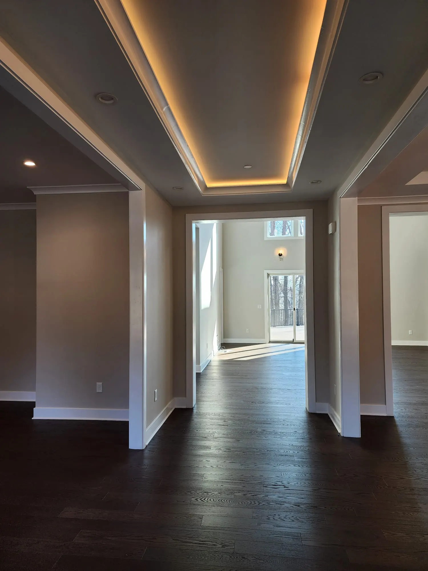 Hallway with tray ceiling and warm cove lighting