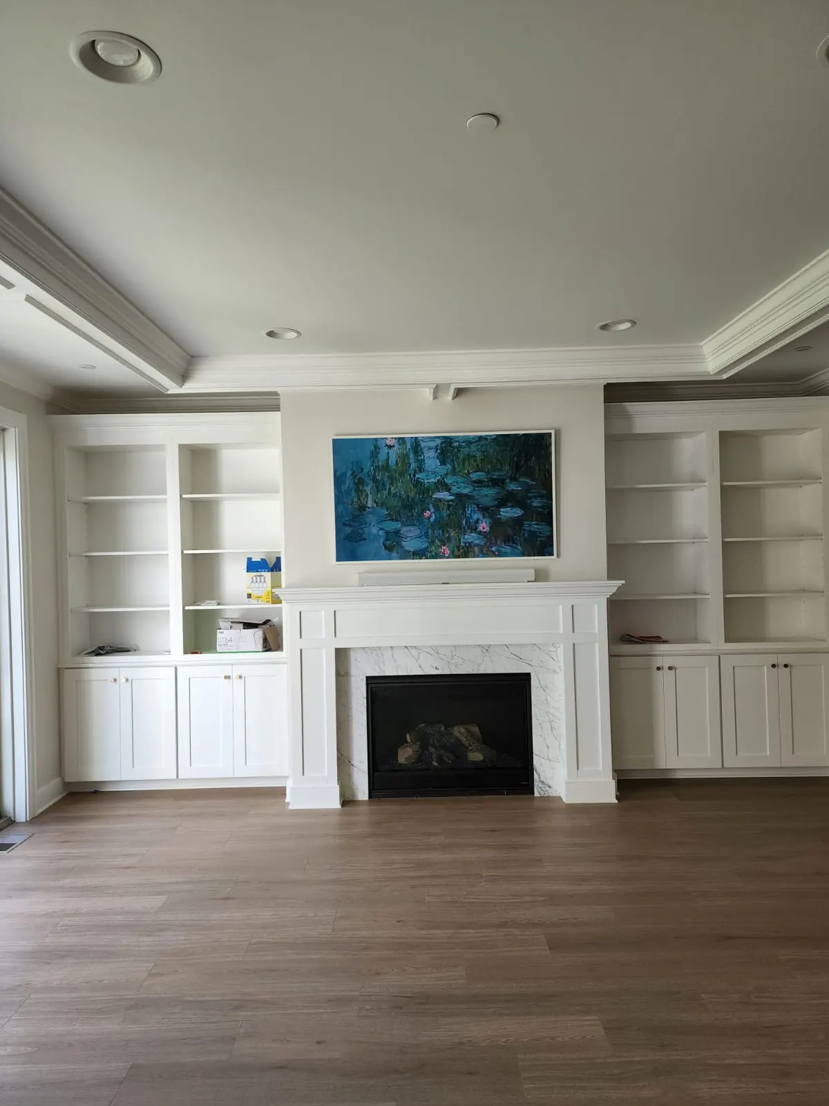 Family room with white built-ins and marble fireplace surround