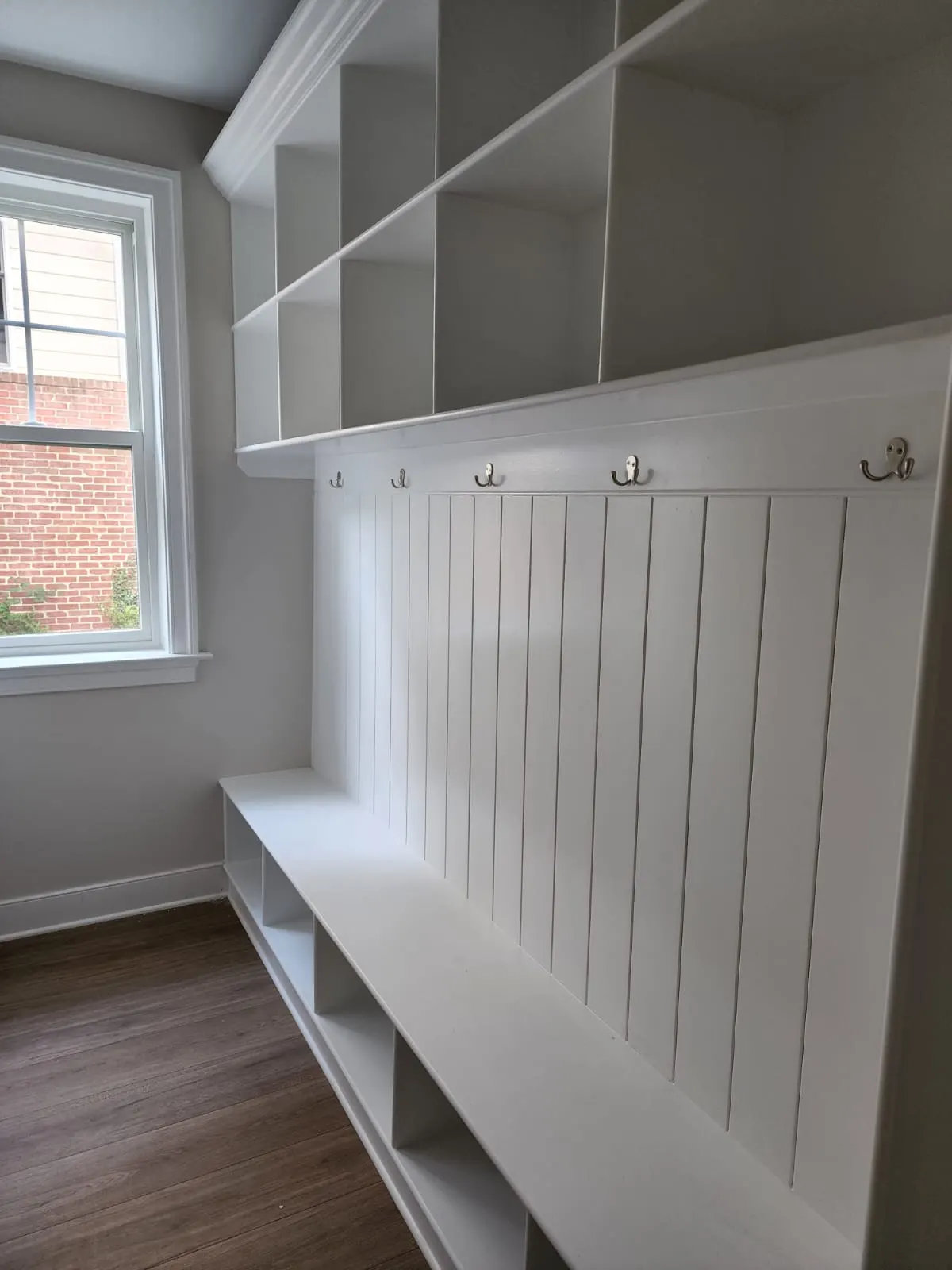 Mudroom with built-in bench, cubbies, and coat hooks