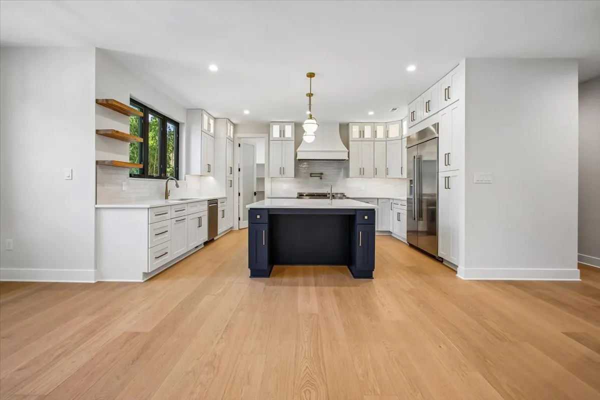 Kitchen with navy island and brass pendants at 6003 Melvern Dr