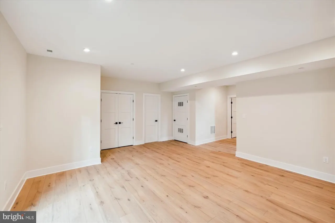Finished basement room with wood floors and white closets