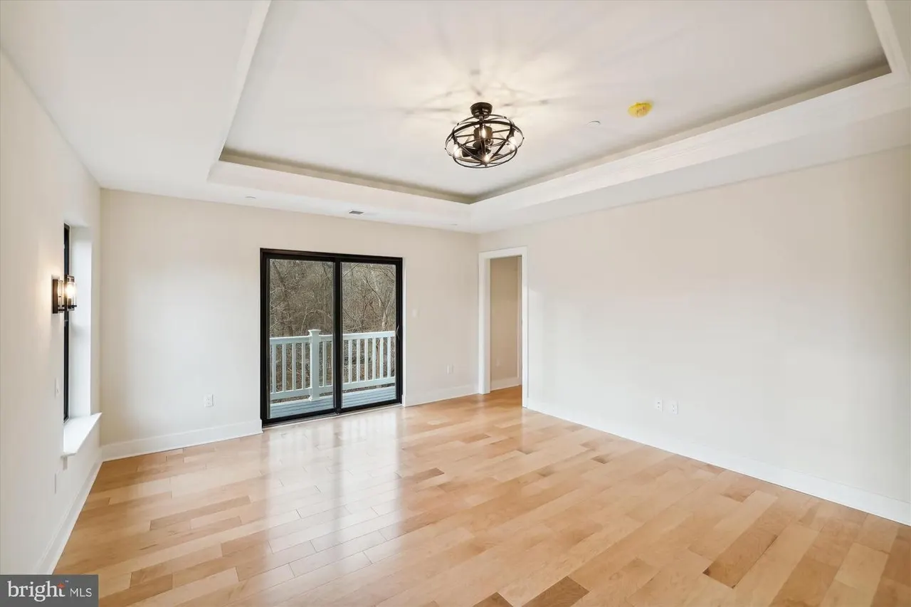 Empty living room with coffered ceiling and glass doors to deck
