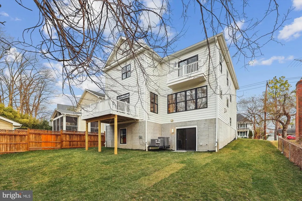 White two-story house with deck and manicured backyard