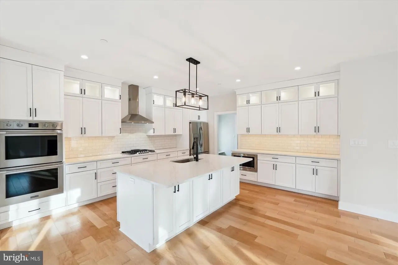 Kitchen with white cabinets, island, and stainless steel appliances