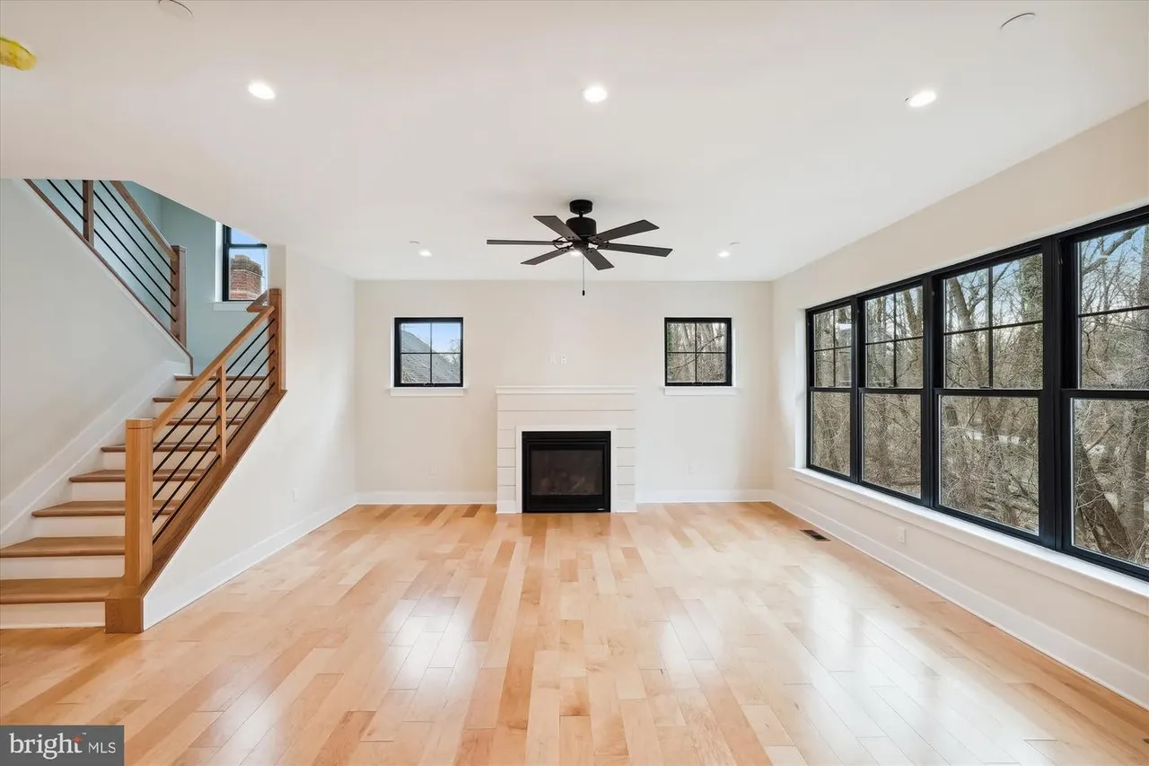 Family room with fireplace, stairs, and black-framed glass doors