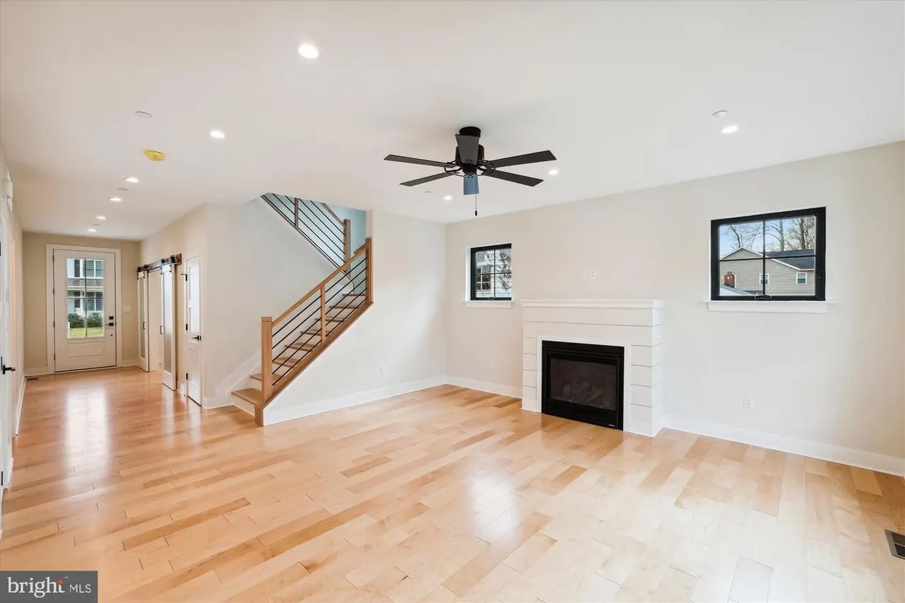 Great room with fireplace, staircase, and hardwood floors
