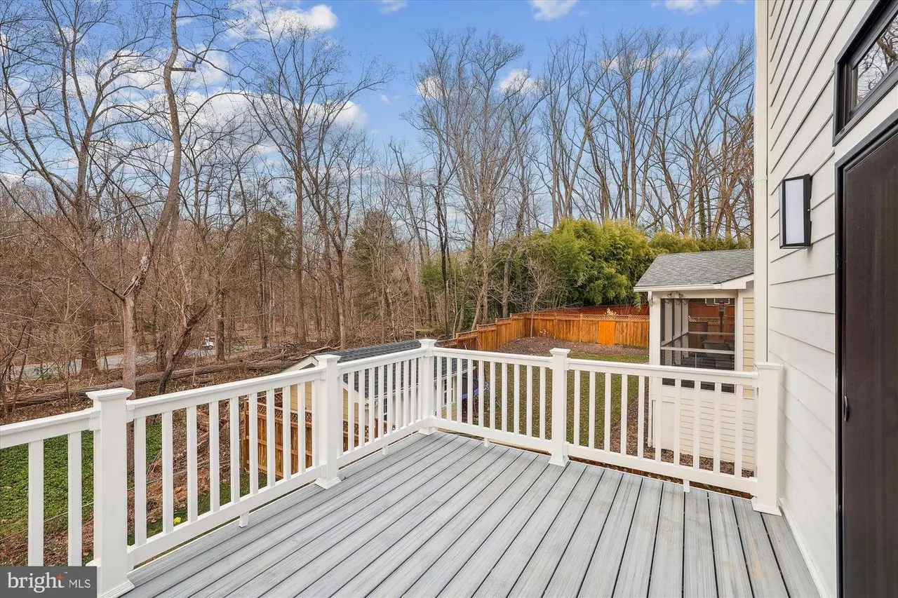 Composite deck with white railings overlooking wooded area