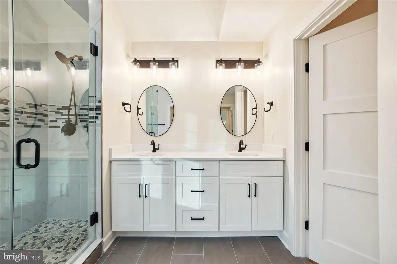 Primary bathroom with dual vanity, walk-in shower, and tile flooring