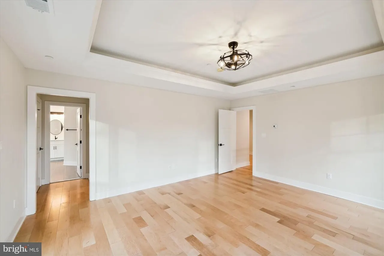 Spacious bedroom with coffered ceiling and wood flooring