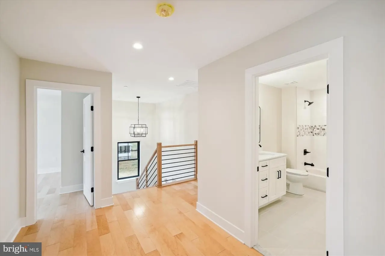 Upstairs hallway with stair railing and ensuite bathroom access