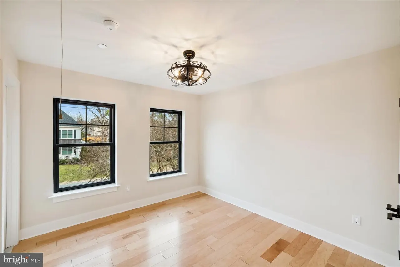 Bedroom with wood floors, black-framed windows and ceiling fan