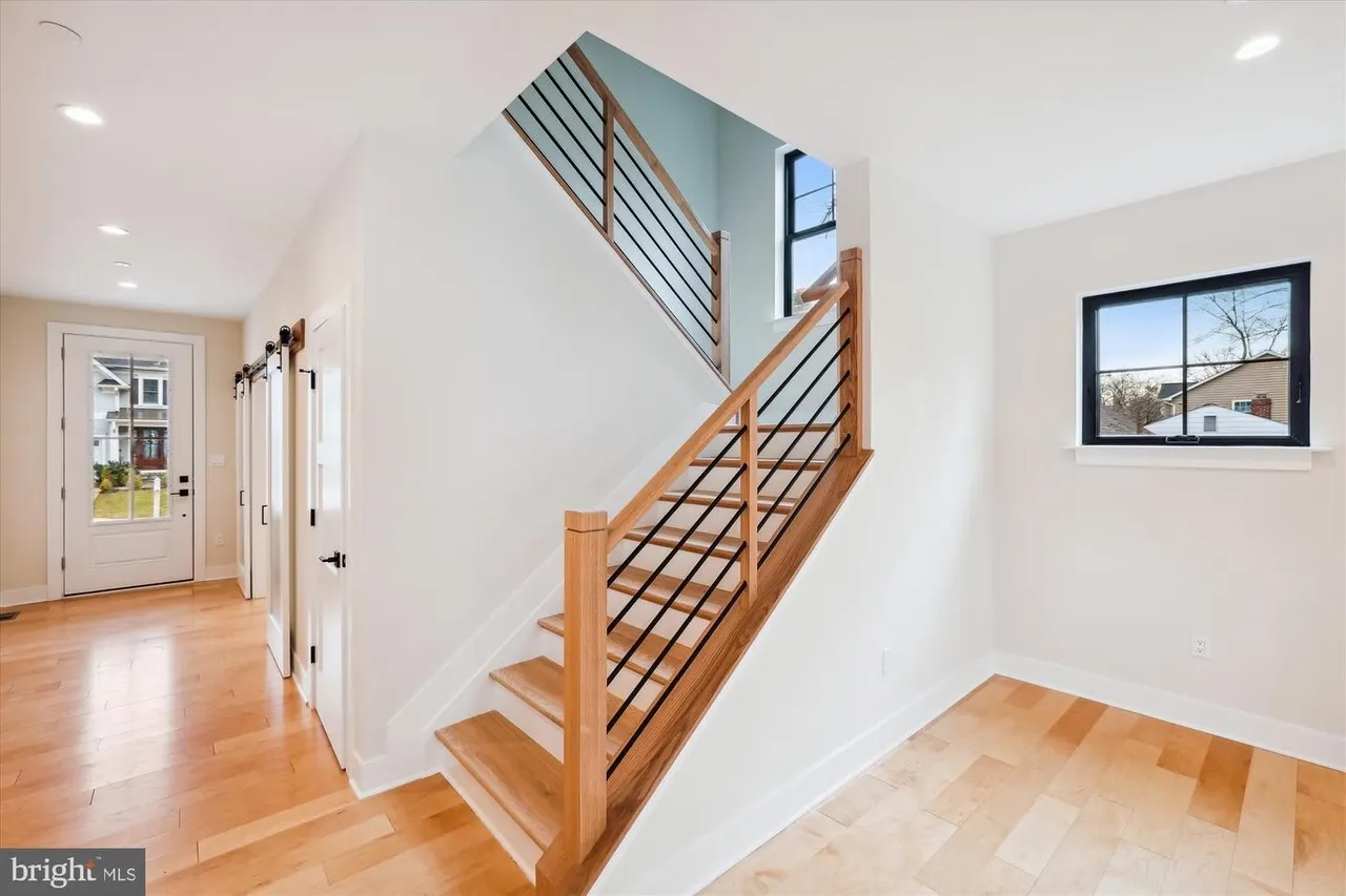 Staircase with wood steps and black metal railing in foyer