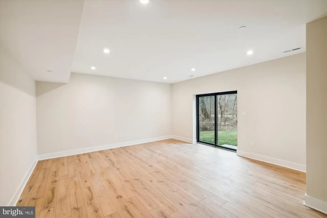 Open room with wood floors and glass doors to outdoor area